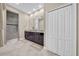 Bathroom featuring a dual sink vanity, linen closet and a glass-enclosed shower at 15405 Woodstar Landing Ct, Lithia, FL 33547