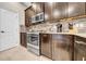 Kitchen showcases stainless steel appliances and modern cabinetry with stylish backsplash and tile flooring at 15405 Woodstar Landing Ct, Lithia, FL 33547