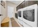Modern laundry room featuring a front-load washer/dryer, ample cabinet space, and neutral walls at 15405 Woodstar Landing Ct, Lithia, FL 33547