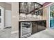 Modern wine bar featuring a built-in wine fridge and glass display cabinets at 15405 Woodstar Landing Ct, Lithia, FL 33547