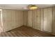 Bedroom with built-in closet, paneled walls, laminated flooring, and ceiling fan at 1710 7Th Sw St # 82, Ruskin, FL 33570