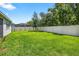 Large, green backyard enclosed by a white fence, offering ample space for outdoor activities and relaxation at 17651 Bright Wheat Dr, Lithia, FL 33547