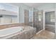 Bathroom featuring a shower, tub, and view of a window at 17651 Bright Wheat Dr, Lithia, FL 33547