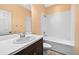Comfortable bathroom with a toilet, sink, and shower-tub combo with white tile at 17651 Bright Wheat Dr, Lithia, FL 33547