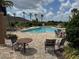 Inviting community pool area with comfortable lounge chairs, tables, and lush landscaping for relaxation at 17651 Bright Wheat Dr, Lithia, FL 33547