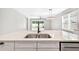 Stylish kitchen with an island featuring a stainless steel sink and views of the living area at 17651 Bright Wheat Dr, Lithia, FL 33547