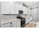 Well-lit kitchen with white cabinets, stainless steel appliances, and stone countertops at 17651 Bright Wheat Dr, Lithia, FL 33547
