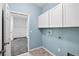 Bright laundry room with built-in cabinets and tile floor at 17651 Bright Wheat Dr, Lithia, FL 33547