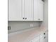 Bright laundry room featuring white cabinets, a sleek countertop, and ample storage space at 17651 Bright Wheat Dr, Lithia, FL 33547