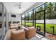 Relaxing screened patio with outdoor seating, ceiling fan, and views of the well-maintained backyard at 17651 Bright Wheat Dr, Lithia, FL 33547