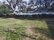 Large grassy backyard featuring a white fence, mature trees, and plenty of space for outdoor activities at 1922 Marvy Ave, Tampa, FL 33612