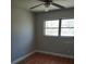 A cozy bedroom featuring hardwood floors, a ceiling fan, and a bright window at 1922 Marvy Ave, Tampa, FL 33612