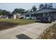 A modest one story home is shown from the street with a newly paved driveway and small front yard at 1922 Marvy Ave, Tampa, FL 33612