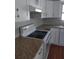 Close up on a kitchen with laminate countertops, white cabinets, new appliances, and laminate flooring at 1922 Marvy Ave, Tampa, FL 33612