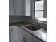 Modern kitchen sink with granite countertops, white cabinets, a window, and updated fixtures at 1922 Marvy Ave, Tampa, FL 33612