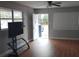 Living room with vinyl flooring, a ceiling fan, light-colored walls, and an exterior door at 1922 Marvy Ave, Tampa, FL 33612