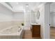 Bright bathroom features a soaking tub with marble surround and a wooden vanity with a vessel sink at 2002 Carolina Ne Cir, St Petersburg, FL 33703