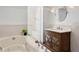 Elegant bathroom features a soaking tub, wood vanity with marble countertop, and a large decorative mirror at 2002 Carolina Ne Cir, St Petersburg, FL 33703