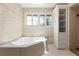 Bathroom featuring a soaking tub and a frosted window at 2002 Carolina Ne Cir, St Petersburg, FL 33703