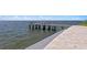Private dock featuring sturdy wooden pilings and concrete structure along the seawall on a sunny day at 2002 Carolina Ne Cir, St Petersburg, FL 33703
