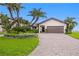 Charming single-story home with lush landscaping, a circular driveway, and a two-car garage at 2002 Carolina Ne Cir, St Petersburg, FL 33703