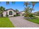 Charming front exterior with lush tropical landscaping, brick driveway, and inviting curb appeal at 2002 Carolina Ne Cir, St Petersburg, FL 33703