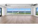 Bright living room featuring large windows with waterfront views and ceiling fans at 2002 Carolina Ne Cir, St Petersburg, FL 33703