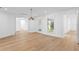 Spacious living room with hardwood floors, stylish lighting, and view of outdoor greenery through shuttered windows at 2002 Carolina Ne Cir, St Petersburg, FL 33703