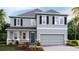 Charming two-story home with gray siding, stone accents, and a two-car garage at 2328 Stratten Dr, Zephyrhills, FL 33541