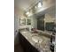 Bathroom features double sinks with granite countertops, vanity lights, and a large mirror at 2411 Willimette Dr, Wesley Chapel, FL 33543
