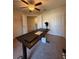 Bedroom features an adjustable desk, ceiling fan, and a view of the hallway at 2411 Willimette Dr, Wesley Chapel, FL 33543