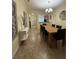 Dining room featuring modern decor, a wooden table, and a view of the front entrance and kitchen at 2411 Willimette Dr, Wesley Chapel, FL 33543