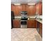 Well-appointed kitchen featuring stainless steel appliances and tile flooring at 2411 Willimette Dr, Wesley Chapel, FL 33543