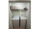 Functional laundry closet with a washer, dryer, and storage shelves at 2411 Willimette Dr, Wesley Chapel, FL 33543