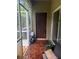 Charming covered patio with wood-look tiles, door to outside, and additional seating at 2411 Willimette Dr, Wesley Chapel, FL 33543