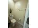 Small, simple half bathroom with a toilet, towel bar, and decorative greenery at 2411 Willimette Dr, Wesley Chapel, FL 33543