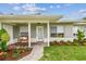 Inviting front porch with decorative plants, charming bench, and a beautiful leaded glass front door at 2452 Bayshore Blvd, Dunedin, FL 34698