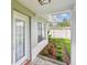 Covered front porch featuring brick flooring, a decorative door, and a manicured landscape bed at 2452 Bayshore Blvd, Dunedin, FL 34698