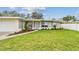 Attractive gray house with a brick path leading to the front porch, with a lush green lawn at 2452 Bayshore Blvd, Dunedin, FL 34698