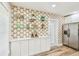Bright kitchen features stylish shelving, stainless steel refrigerator, and unique decorative wallpaper at 2452 Bayshore Blvd, Dunedin, FL 34698