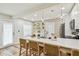 Open kitchen with island seating, white cabinets, stainless appliances, and a lovely backsplash at 2452 Bayshore Blvd, Dunedin, FL 34698
