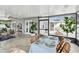 Screened patio featuring a dining table, multiple seating areas and access to an outdoor patio at 2452 Bayshore Blvd, Dunedin, FL 34698