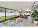 Screened lanai featuring dining set, ceiling fan, and access to an outdoor seating area at 2452 Bayshore Blvd, Dunedin, FL 34698