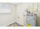 Well-lit utility room featuring an AO Smith 100 water heater and neutral paint at 2452 Bayshore Blvd, Dunedin, FL 34698