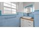 Charming bathroom featuring blue tiled walls, a white vanity, and natural light at 2819 N Central Ave, Tampa, FL 33602