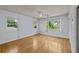 Sunlit bedroom with hardwood floors, neutral walls, and three windows at 2819 N Central Ave, Tampa, FL 33602