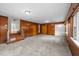 Spacious living room with wood paneling, neutral carpet, and multiple doors and windows at 2819 N Central Ave, Tampa, FL 33602