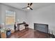 Bedroom with wood flooring, a ceiling fan, and a window with blinds, creating a comfortable atmosphere at 2823 Holly Bluff Ct, Plant City, FL 33566
