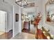 Open foyer with dark wood floors transitioning to tile, decorative console table, and view into living areas at 2823 Holly Bluff Ct, Plant City, FL 33566