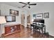 This home office features hardwood floors, a ceiling fan, and ample wall decor at 2823 Holly Bluff Ct, Plant City, FL 33566